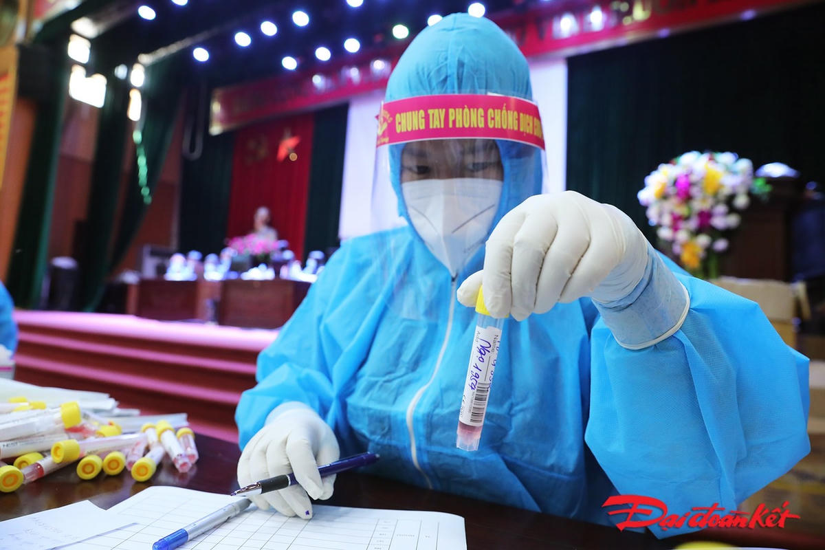 Nhân viên y tế cẩn trọng trong ghi chép thông tin các mẫu xét nghiệm. Ảnh: Quang Vinh. 