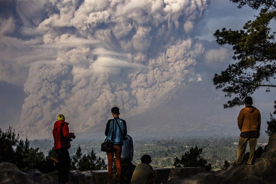 ​12. Người dân xung quanh đứng xem núi Sinabung phun tro vào không khí trong một vụ phun trào tại Karo Regency, Indonesia, vào ngày 09 tháng 02 năm 2015. Ảnh Endro Lewa / Antara Photo Agency / Reuters.