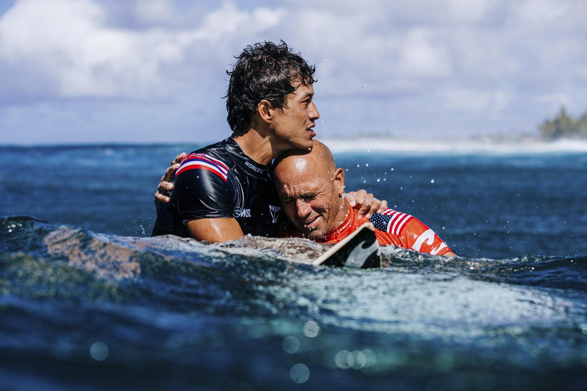 Seth Moniz và Kelly Slater, người Mỹ, ôm nhau sau khi Slater chiến thắng trong cuộc thi lướt sóng Billabong Pro Pipeline gần sinh nhật lần thứ 50 ở Haleiwa. Ảnh: Brent Bielmann / World Surf League / AP.