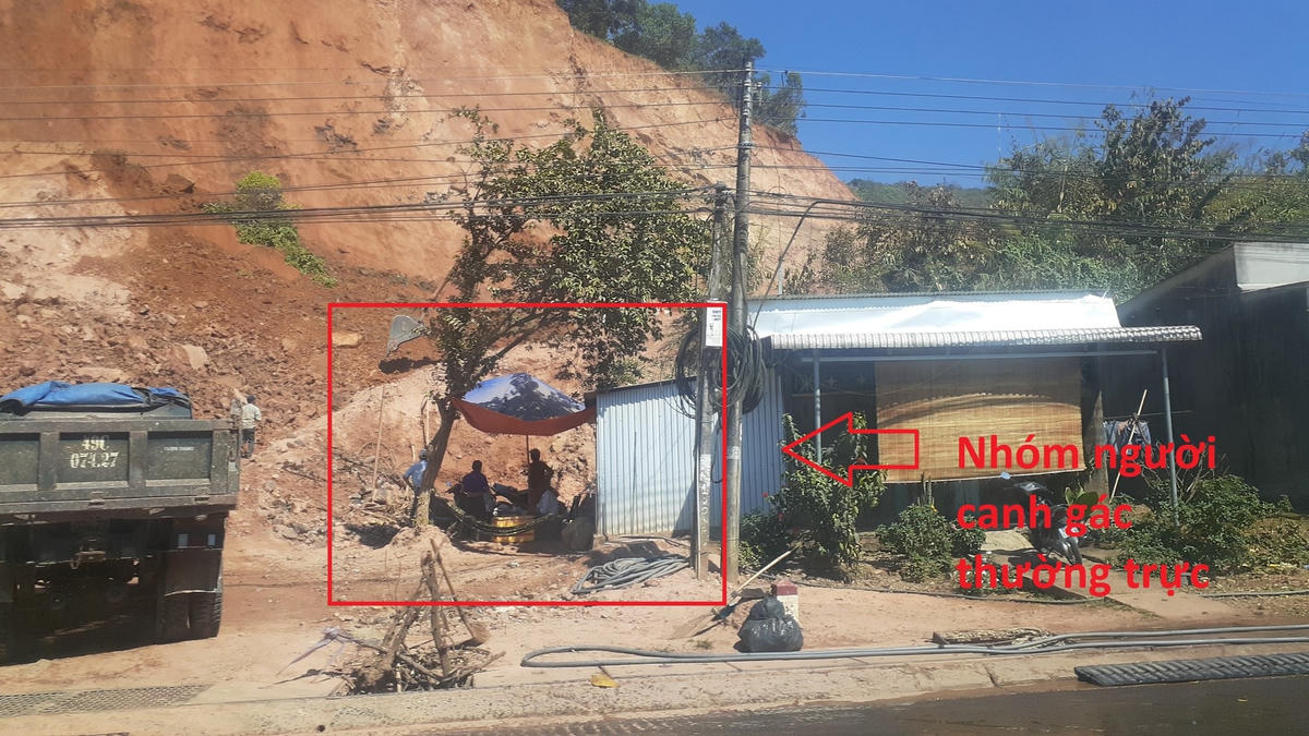 Một nhóm người canh gác thưởng trực ở điểm ra vào dự án