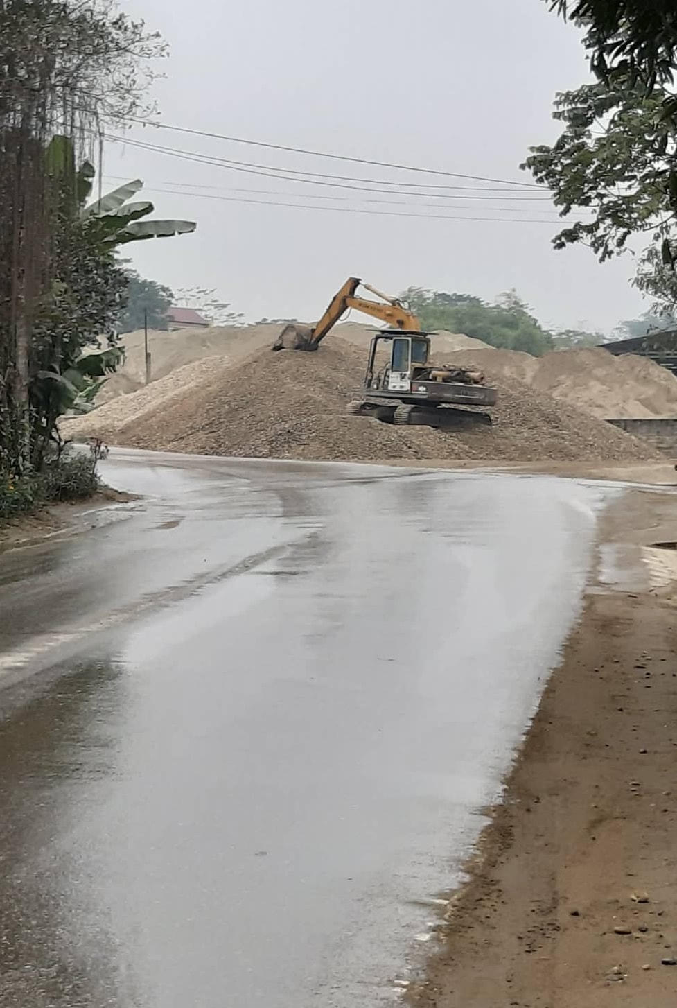 Bãi chứa cát sỏi của DN Tiến Thuận, phường Tân Hà, tràn cả ra đường, gây nguy hiểm cho người tham gia giao thông. Ảnh chụp sáng 6/1/2021.