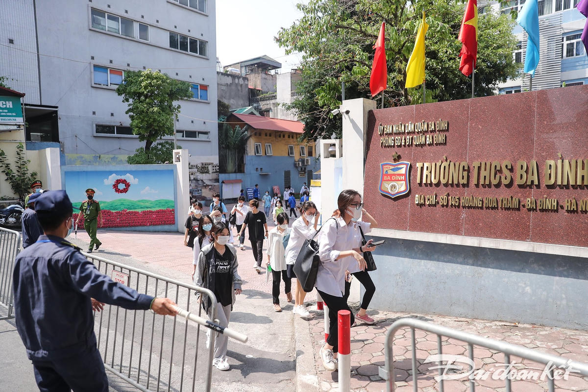 Các thí sinh hoàn thành bài thi đầu tiên. Thời điểm tan trường trời khá nắng. Lực lượng chức năng đã có mặt để phân luồng và đảm bảo an toàn giao thông. Ảnh: Quang Vinh.