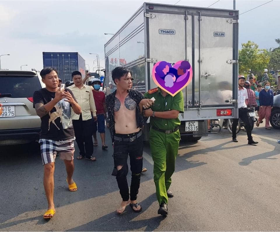 Thanh niên (ở giữa) bị công an đưa về đồn làm việc.