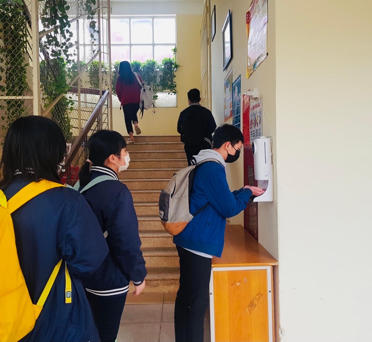 Học sinh Trường THCS Bế Văn Đàn (quận Đống Đa) kiểm tra thân nhiệt, sát khuẩn tay trước khi vào lớp học trong sáng 14/2.