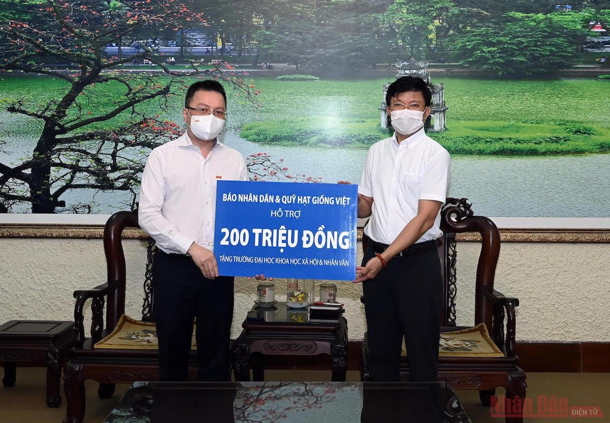 Ông Lê Quốc Minh, Tổng Biên tập Báo Nhân Dân trao quà hỗ trợ Trường đại học Khoa học Xã hội và Nhân văn. Ảnh: Duy Linh.  