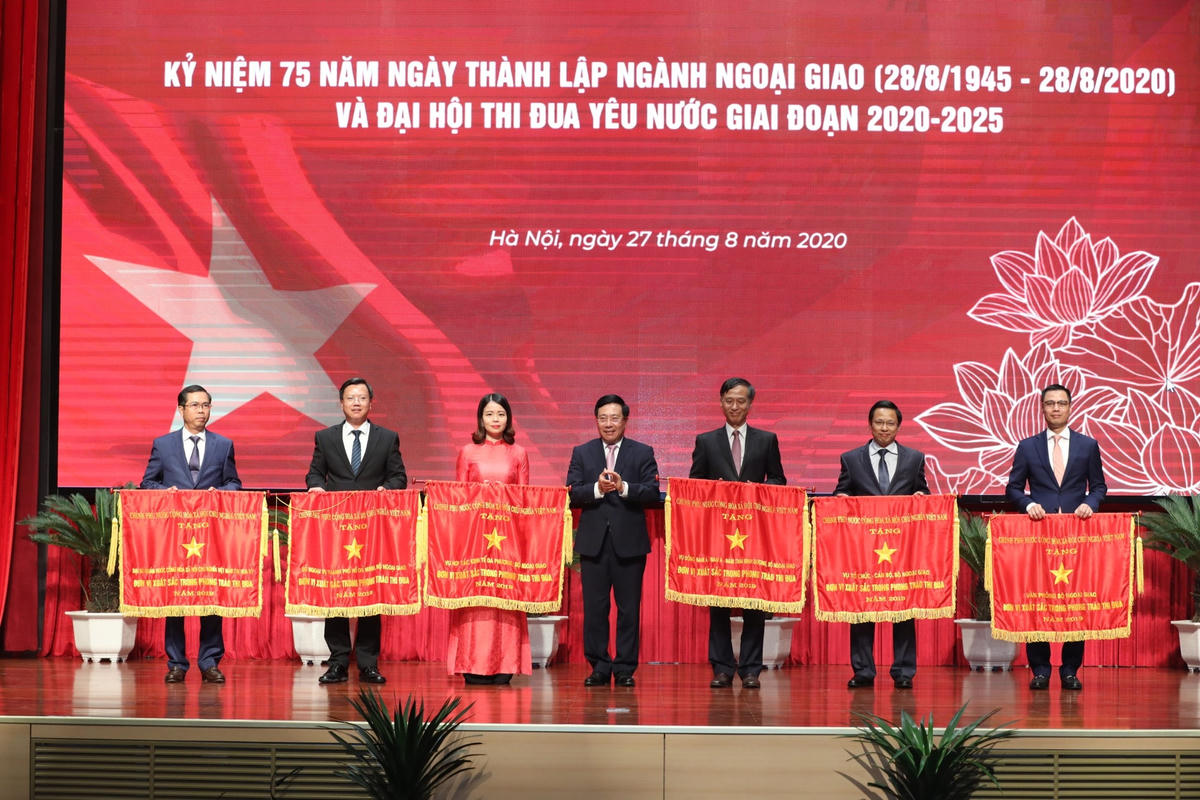 Phó Thủ tướng, Bộ trưởng Ngoại giao Phạm Bình Minh trao cờ thi đua của Chính phủ cho các tập thể xuất sắc. Ảnh: Quang Vinh.