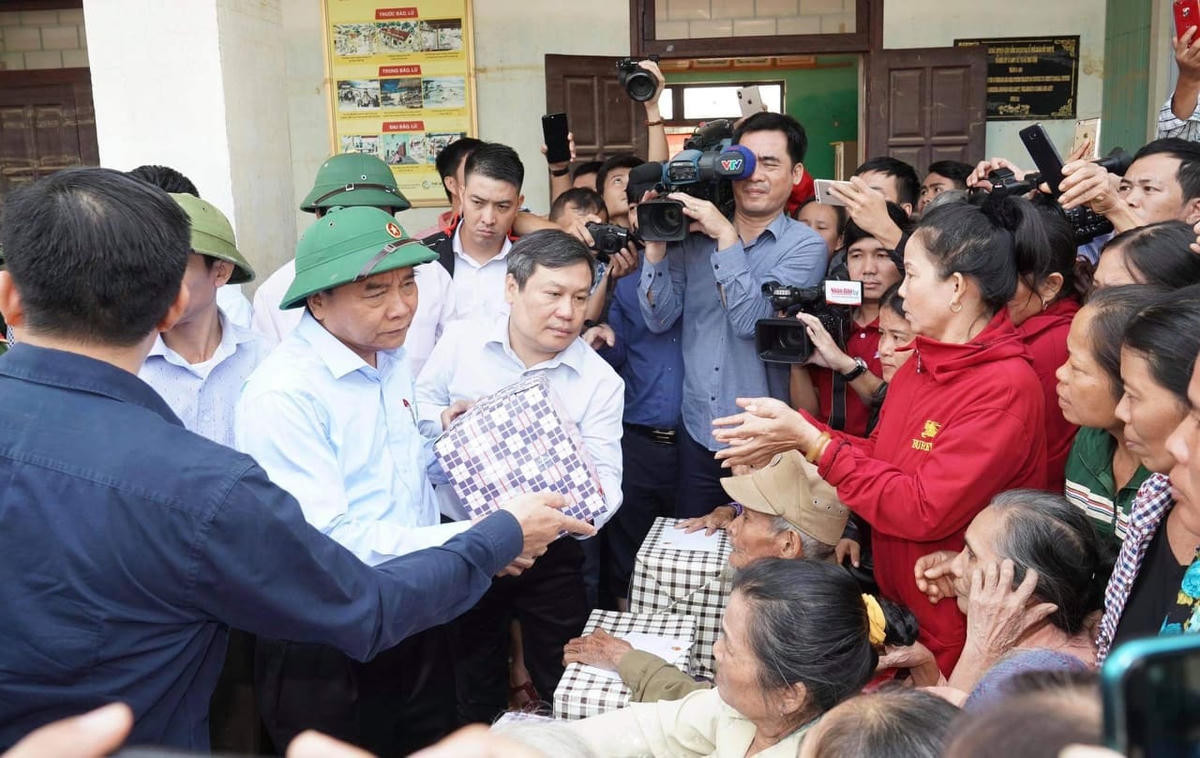 Thủ tướng Nguyễn Xuân Phúc trò chuyện, tặng quà bà con vùng lũ. Ảnh: Quang Hiếu.