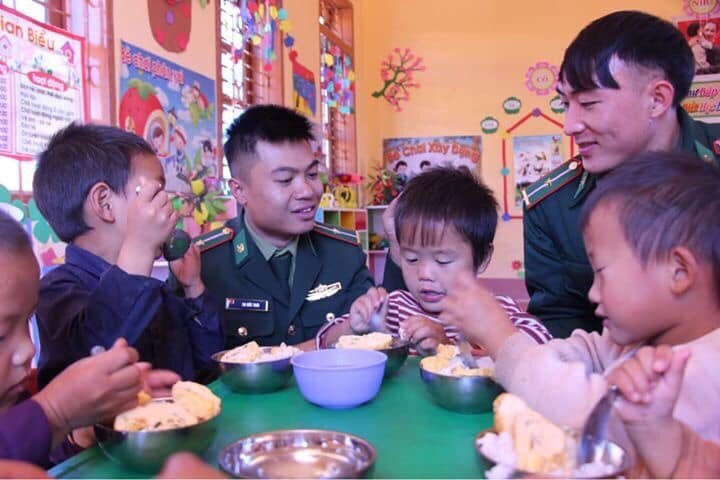 Chiến sỹ Đồn Biên phòng cửa khẩu Lóng Sập chăm lo bữa sáng cho trẻ em ở bản Buốc Pát.