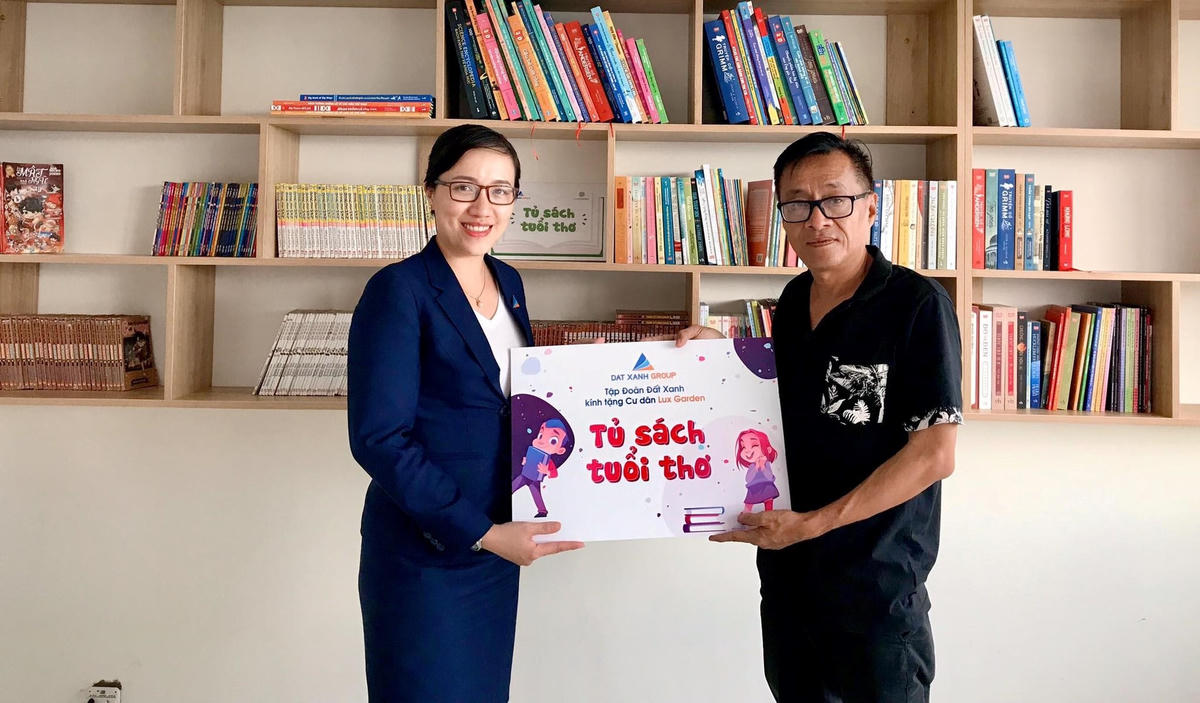 Bà Diệp Thùy Linh - Giám đốc Dịch vụ khách hàng, Tập đoàn Đất Xanh trao tặng Tủ sách Tuổi Thơ cho ông Nguyễn Anh Tuấn - Trưởng ban quản trị khu căn hộ Lux Garden.  