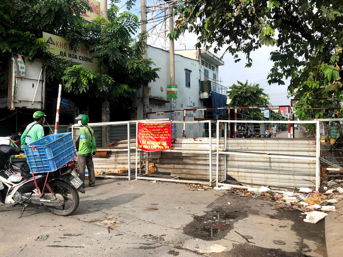Một chốt chặn 2 lớp ở Quận 12. Đây là tuyến đường khá lớn nhưng hiện nay người dân không thể di chuyển ra/vào bằng bất cứ phương tiện nào. Các giao dịch mua bán hàng hóa đều thực hiện ở chốt.
