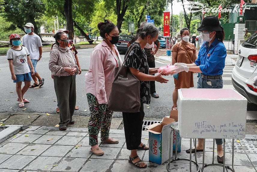 Báo Đại Đoàn Kết và nhóm tình nguyện phát suất ăn cho những hoàn cảnh khó khăn, những người vô gia cư. Ảnh: Quang Vinh.