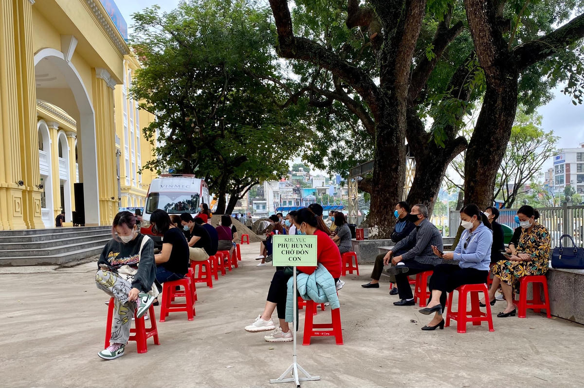 Các phụ huynh được bố trí ngồi chờ đón con tại 1 khu vực riêng.