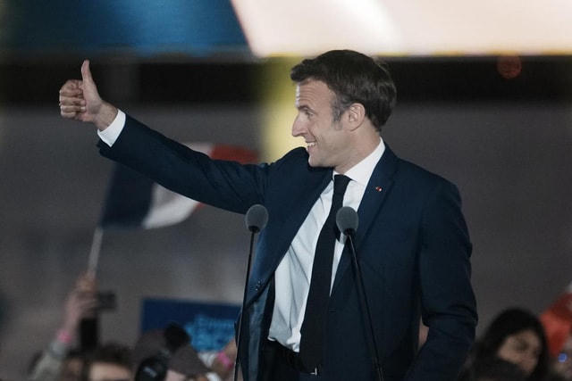 Tổng thống Pháp Emmanuel Macron ăn mừng với những người ủng hộ tại Paris, ngày 24/4. Ảnh: AP.