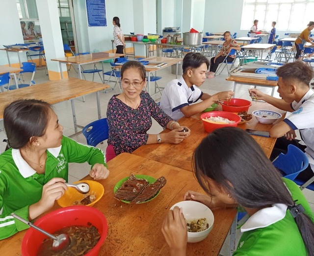 Cô Kim Dung cùng trò chuyện, thăm hỏi các em học sinh nội trú bữa ăn ở nhà ăn sau giờ học.  