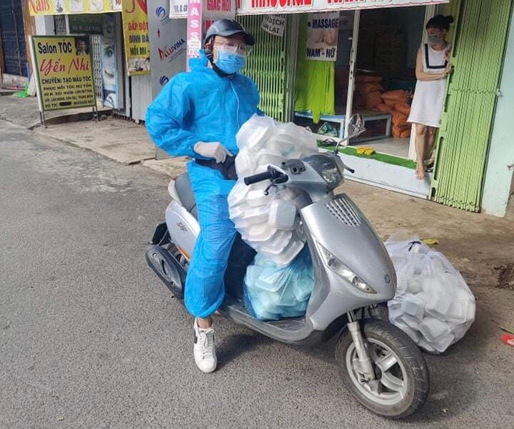 Ngày nào cũng như ngày nào, trên chiếc xe máy, Huân chở theo hàng trăm suất cơm rong ruổi khắp đường phố TP HCM phát cho người nghèo. Ảnh: NVCC.