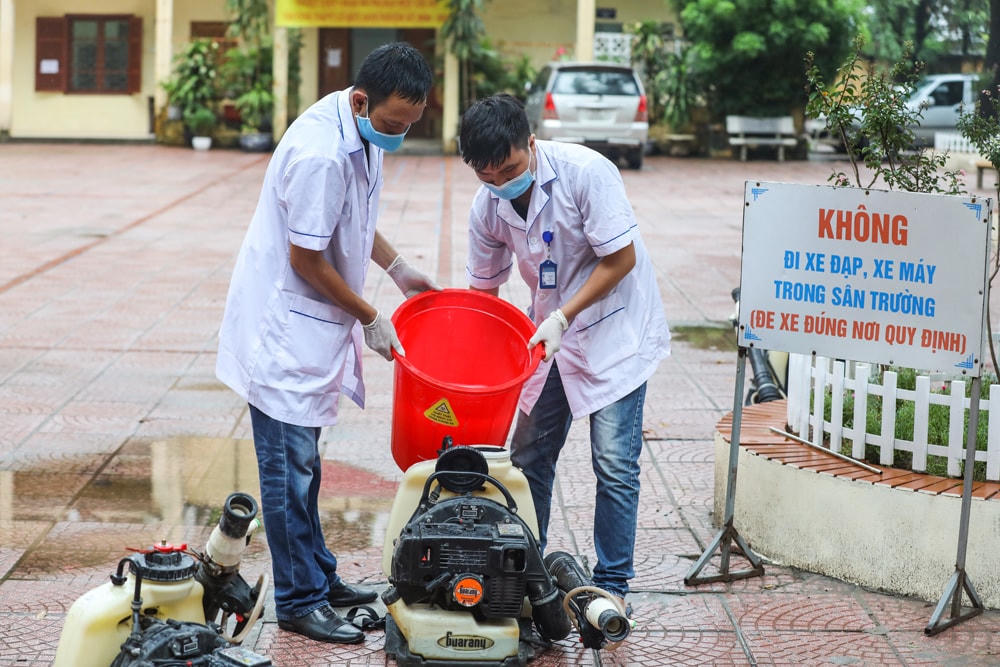 Nhân viên y tế chuẩn bị nước sát khuẩn cho trường học.