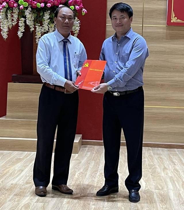 Ông Nguyễn Quốc Việt (bên trái) nhận quyết định chuẩn y chức danh Bí thư Huyện ủy Lý Sơn.
