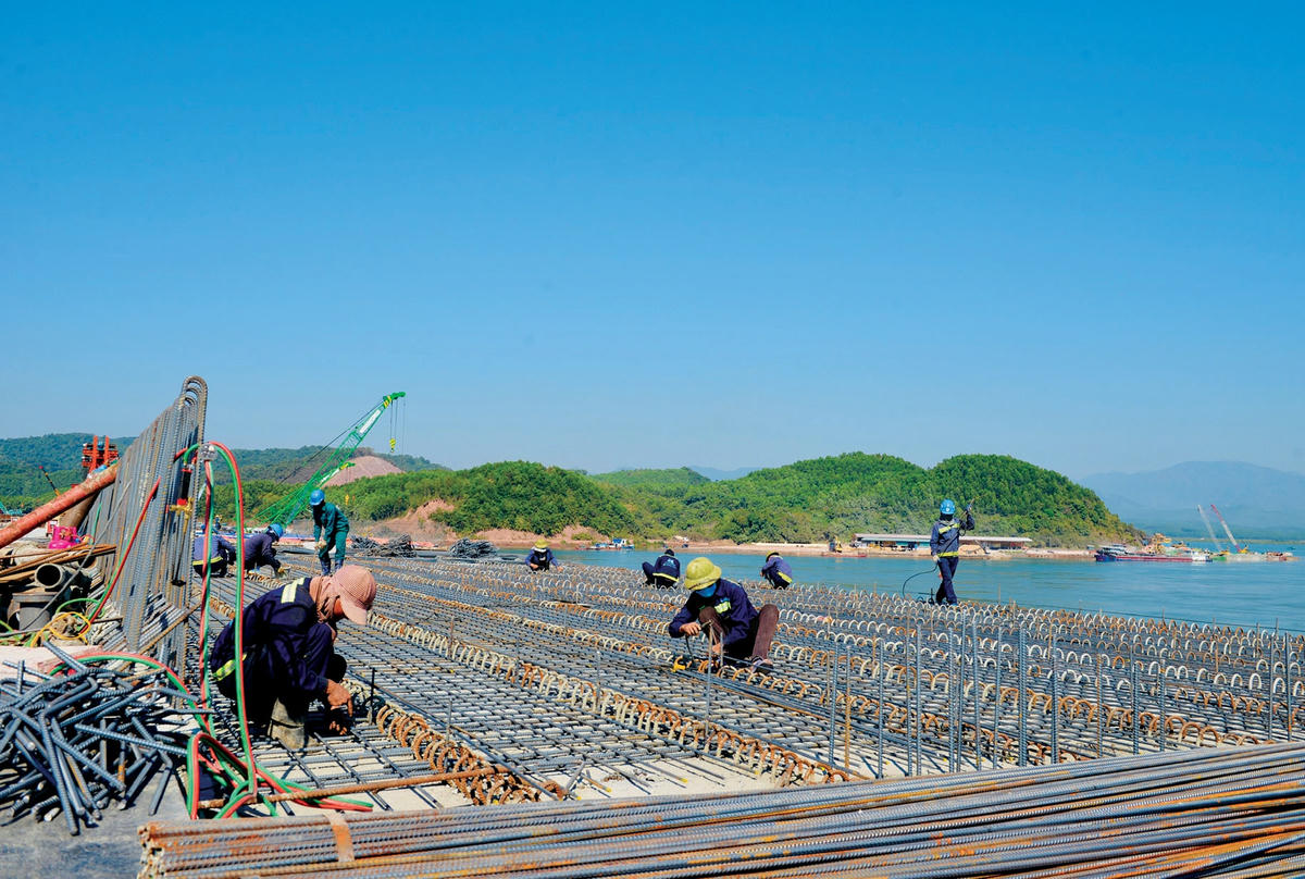 Công nhân thi công buộc thép lưới dưới bản mặt cầu.