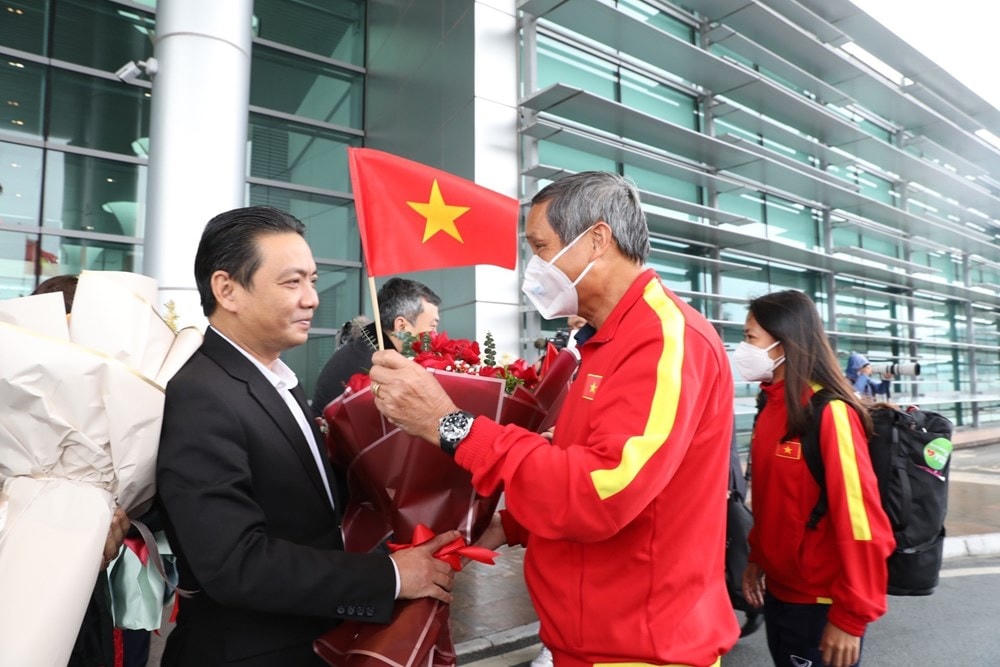 Đại diện Liên đoàn Bóng đá Việt Nam (VFF) tặng hoa chúc mừng Huấn luyện viên trưởng Mai Đức Chung tại sảnh VIP A của sân bay quốc tế Nội Bài. (Ảnh: TTXVN).
