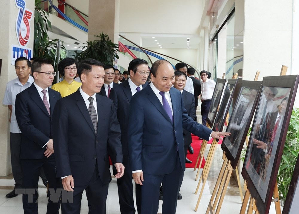 Thủ tướng Nguyễn Xuân Phúc và các đại biểu tham quan Trưng bày ảnh 75 năm TTXVN - Dòng thông tin chính thống không bao giờ ngừng chảy nhân dịp Kỷ niệm 75 năm Ngày thành lập Thông tấn xã Việt Nam (15/9/1945-15/9/2020). (Ảnh: Thống Nhất/TTXVN).