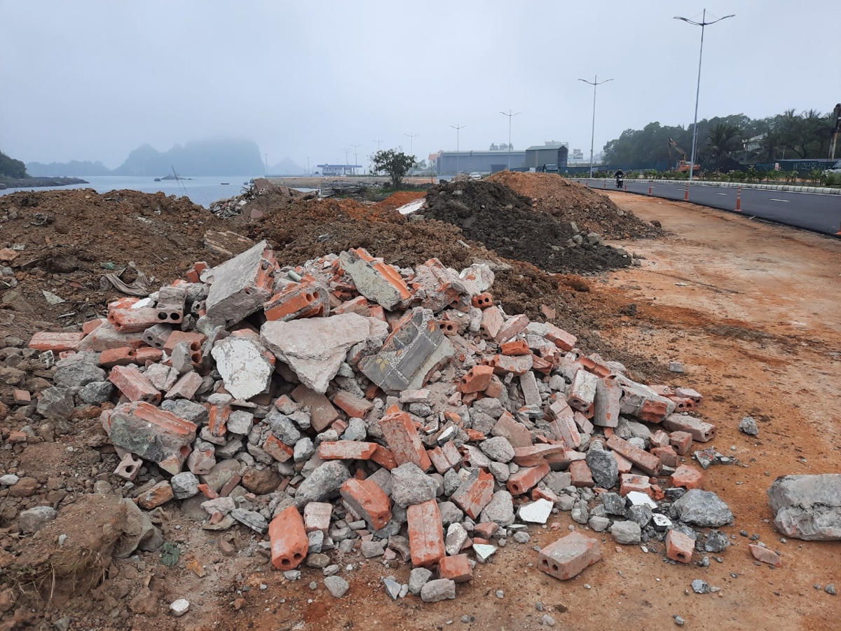 Rác thải xây dựng gồm các loại gạch ngói vỡ, bê tông, cát, đất... đổ chất thành đống cao, tràn lan ở ven đường bao biển Hạ Long - Cẩm Phả.
