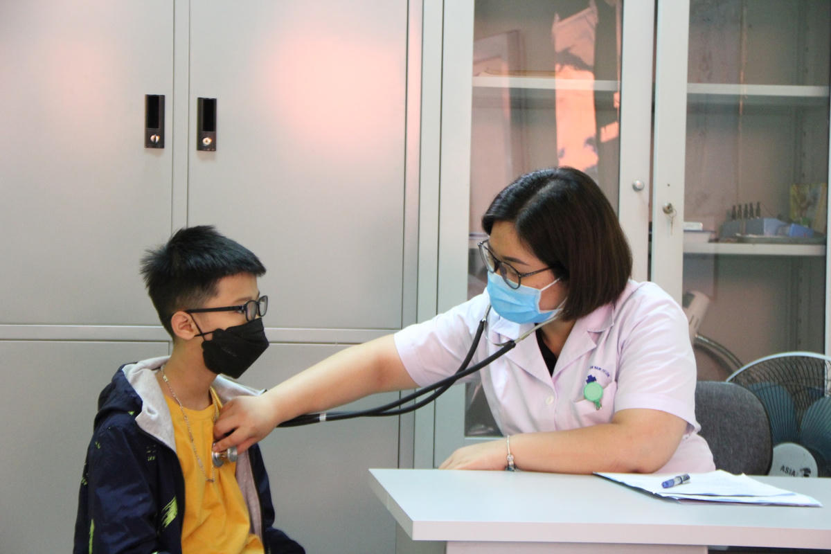 Sau khi hỏi an sức khỏe, bác sỹ tiến hành đo nhịp tim trẻ em.