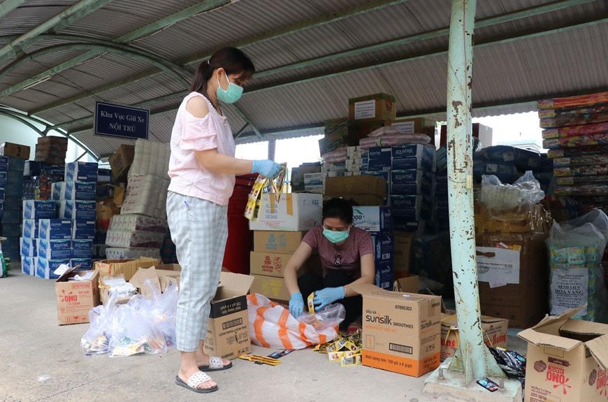 Các điều dưỡng của Trung tâm y tế huyện Hòa Vang có thêm nhiệm vụ phân chia đồ dùng, nhu yếu phẩm. (Ảnh: Quốc Dũng/TTXVN).  