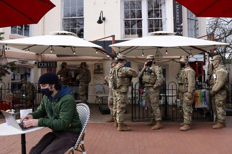 Các thành viên của Lực lượng Vệ binh Quốc gia xếp hàng chờ uống cà phê trong khi nghỉ giải lao.     