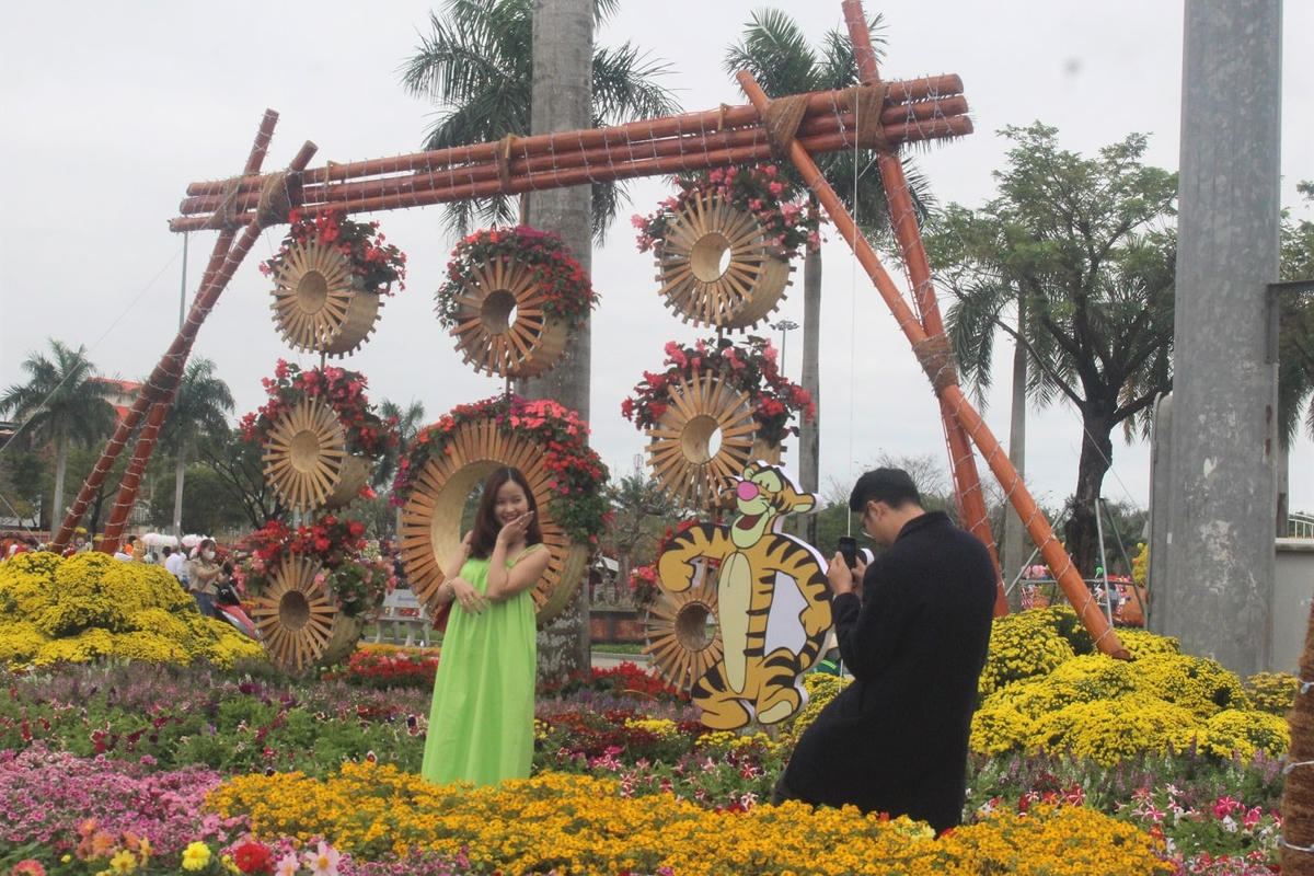 Tạo dáng bên đồ đạc bằng tre, giỏ hoa khoe sắc.