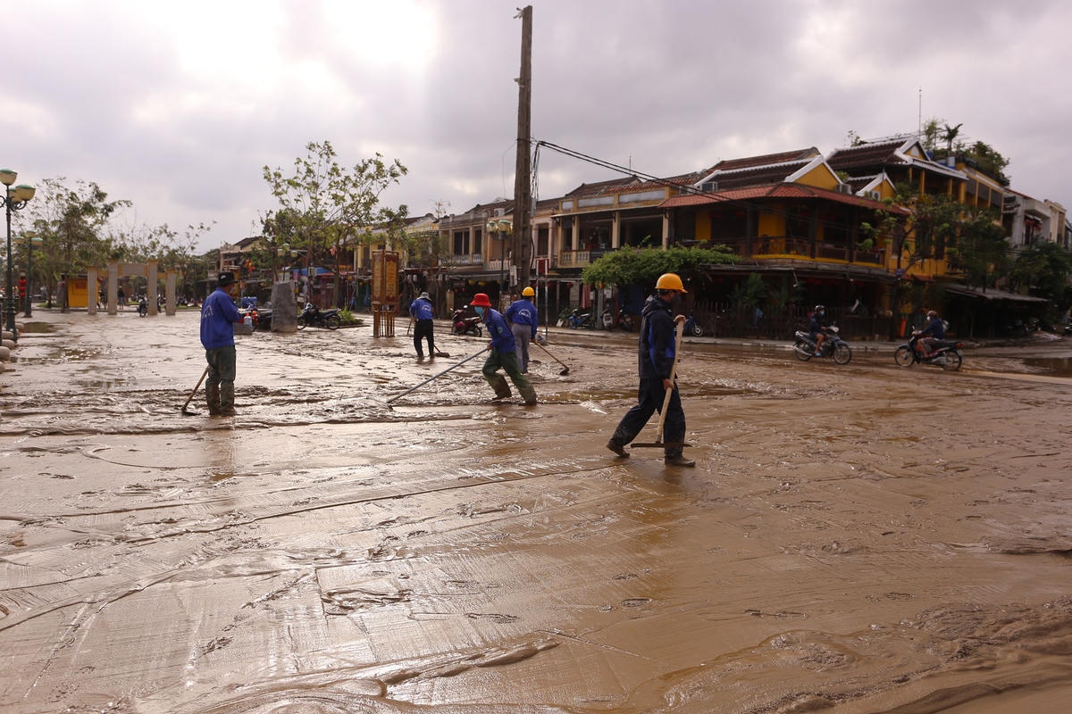 Công nhân đang dọn vệ sinh bùn đất ở đường Nguyễn Phúc Chu.