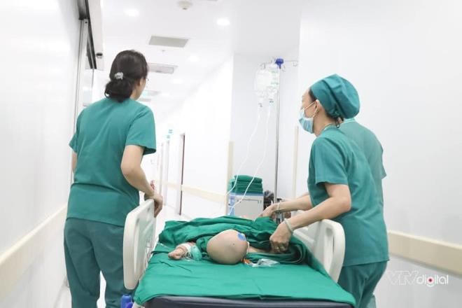 Các bác sĩ đẩy giường của 2 bé vào phòng phẫu thuật. (Ảnh: VTV Digital).