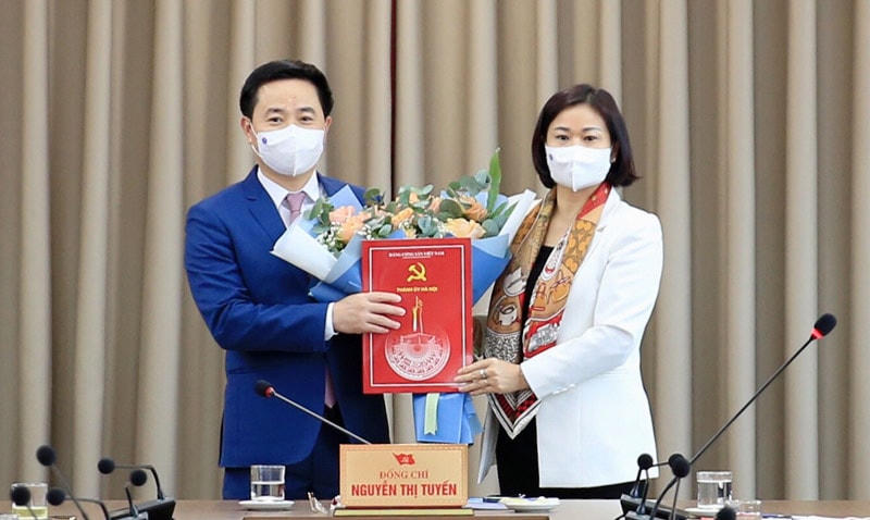 Phó Bí thư Thường trực Thành ủy Hà Nội Nguyễn Thị Tuyến trao Quyết định của Ban Thường vụ Thành ủy và tặng hoa chúc mừng ông Trần Anh Tuấn.