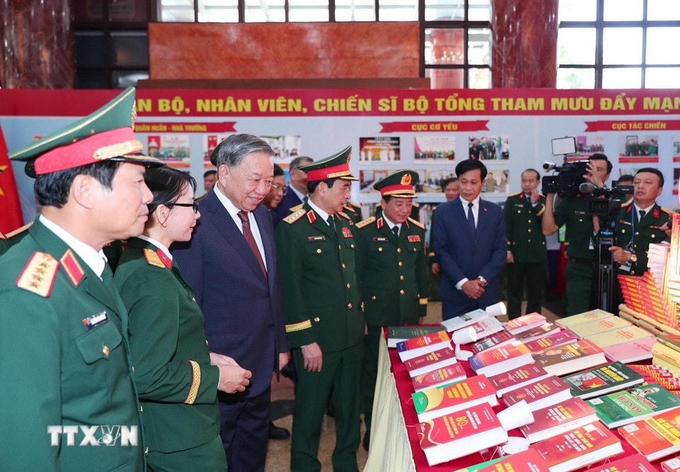 Tổng Bí thư Tô Lâm và các đại biểu tham quan Khu trưng bày ấn phẩm Quốc phòng. (Ảnh: Trọng Đức/TTXVN)