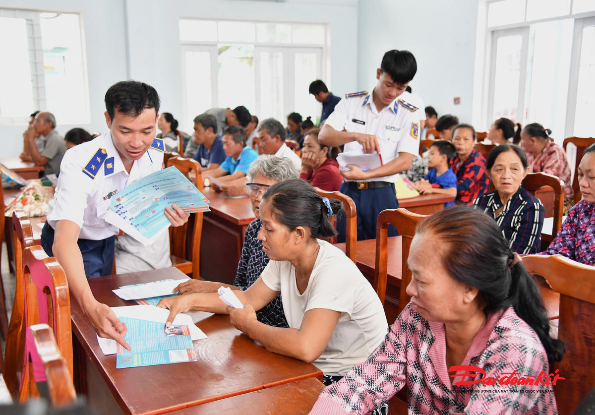 Cành sát biển phát tờ rơi tuyên truyền pháp luật cho bà con ngư dân Thạnh An. Ảnh: Đức Định.