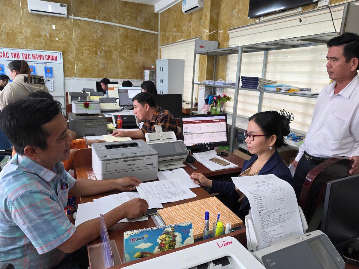 ẢNH 5 Trương Văn Dũng (áo sọc), người dân sinh sống tại địa bàn, đánh giá cao thái độ phục vụ và quy trình xử lý công việc của cán bộ xã Vĩnh Phước.