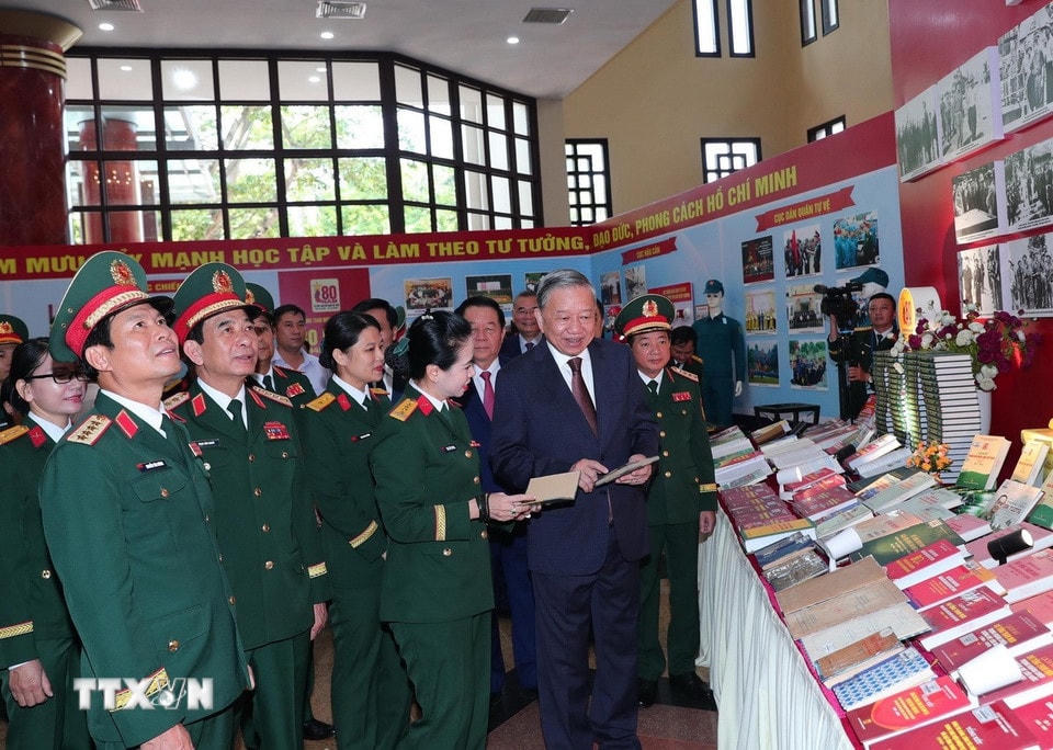 Tổng Bí thư Tô Lâm và các đại biểu tham quan Khu trưng bày ấn phẩm Quốc phòng. (Ảnh: Trọng Đức/TTXVN)