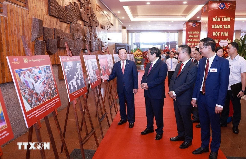 Thủ tướng Phạm Minh Chính tham quan trưng bày ảnh về quá trình hình thành và phát triển của Đài Tiếng nói Việt Nam. (Ảnh: Dương Giang/TTXVN)