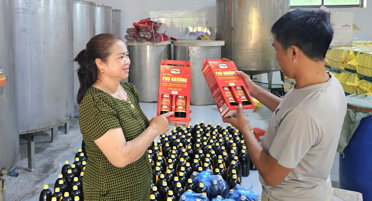 Bà Lê Thị Khương, Giám đốc HTX Phú Khương giới thiệu sản phẩm đạt chuẩn OCOP 4 sao cho khách hàng. Ảnh: Quang Lộc.