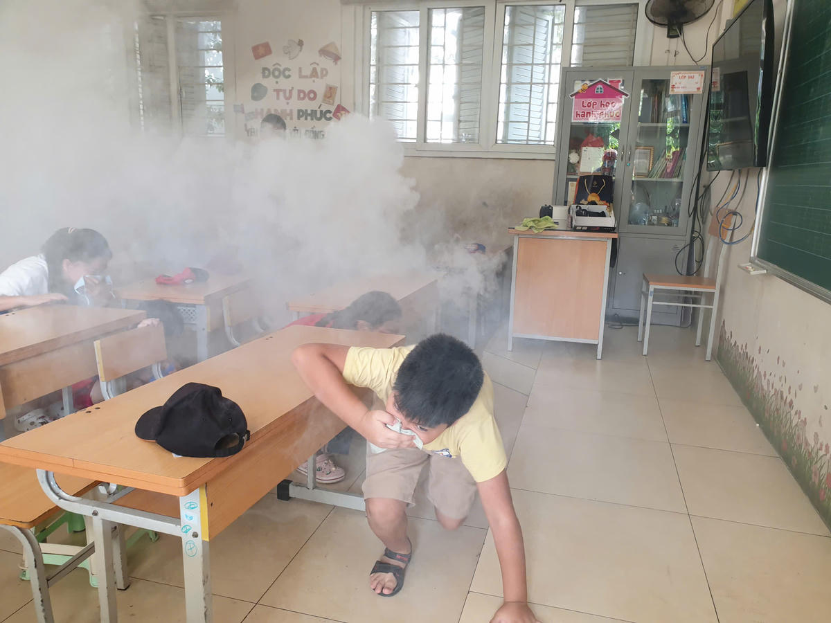 Hướng dẫn học sinh thoát khỏi đám cháy giả định tại buổi tuyên truyền.