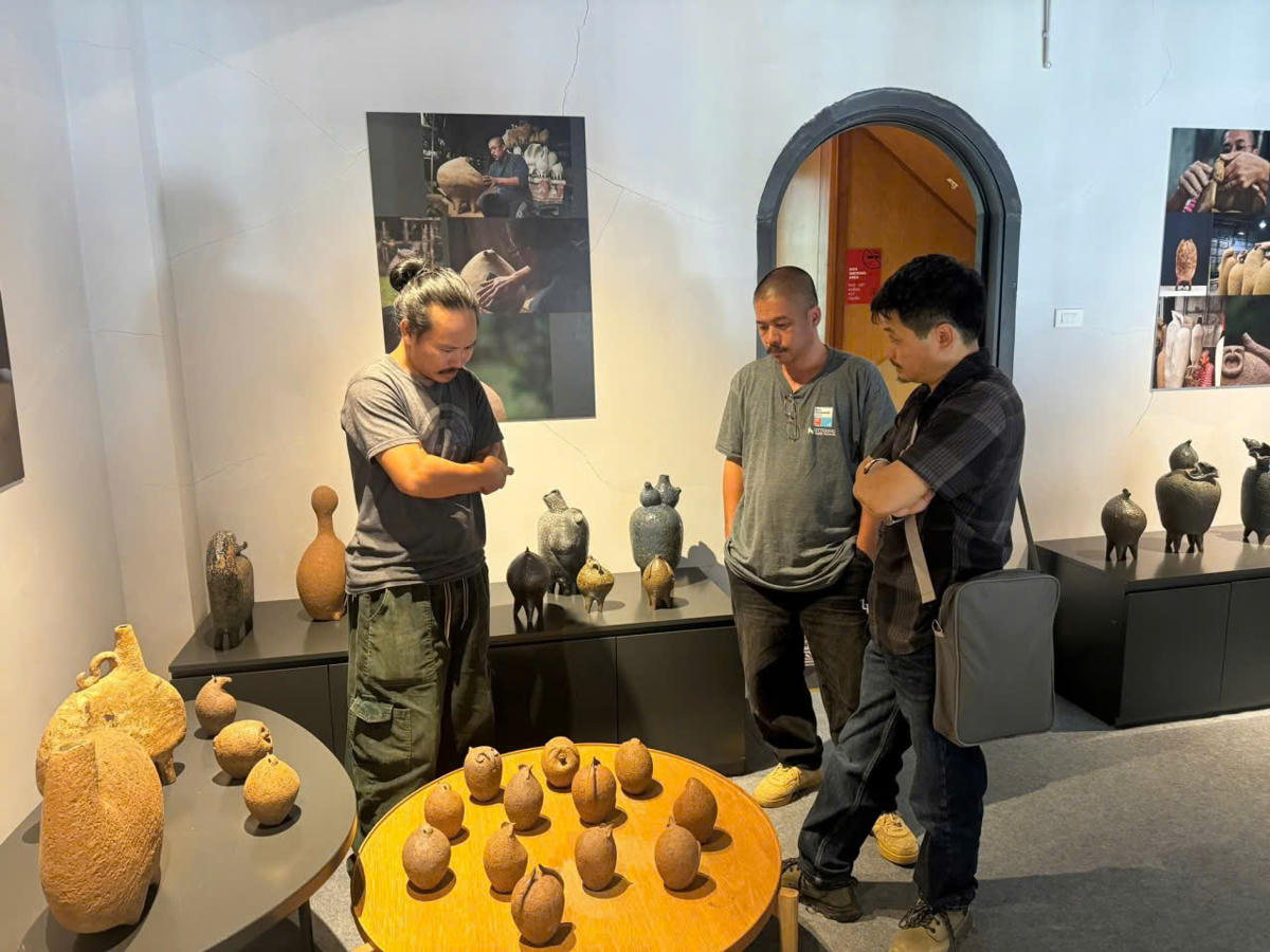 Nghệ sĩ Vũ Đức Hiếu cùng hai đồng nghiệp của anh bên các tác phẩm được trưng bày trong triển lãm "Nét Mường". Ảnh: HM