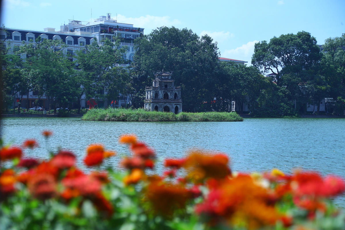 Tháp Rùa, nổi bật giữa không gian Hồ Hoàn Kiếm rực rỡ sắc hoa.
