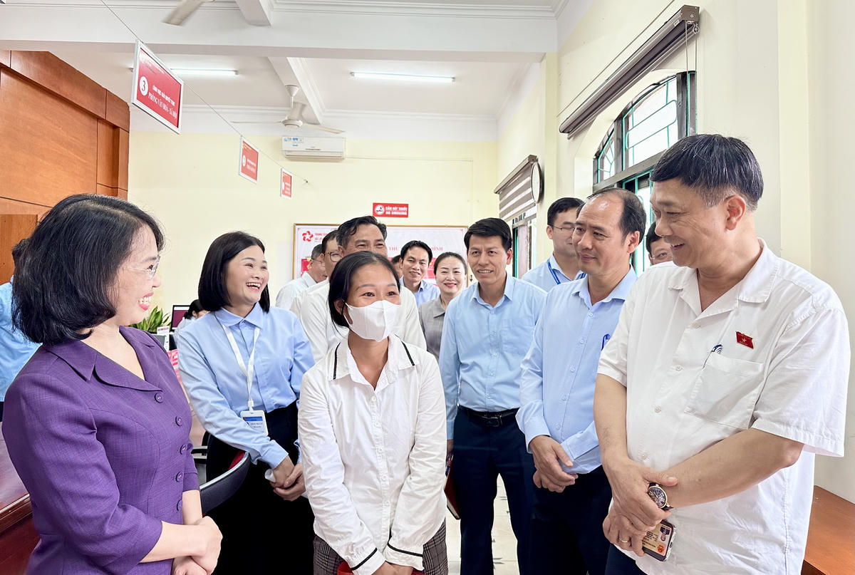 Phó Chủ tịch Quốc hội Vũ Hồng Thanh cùng đoàn công tác của Ủy ban Thường vụ Quốc hội và lãnh đạo tỉnh Quảng Ninh trò chuyện với người dân đến làm TTHC tại Trung tâm Hành chính công xã Lục Hồn. Ảnh: Ngọc Anh.