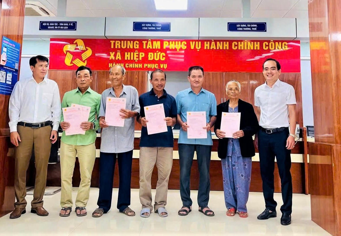 Lãnh đạo UBND xã Hiệp Đức cấp sổ đỏ cho người dân. Ảnh: CV.