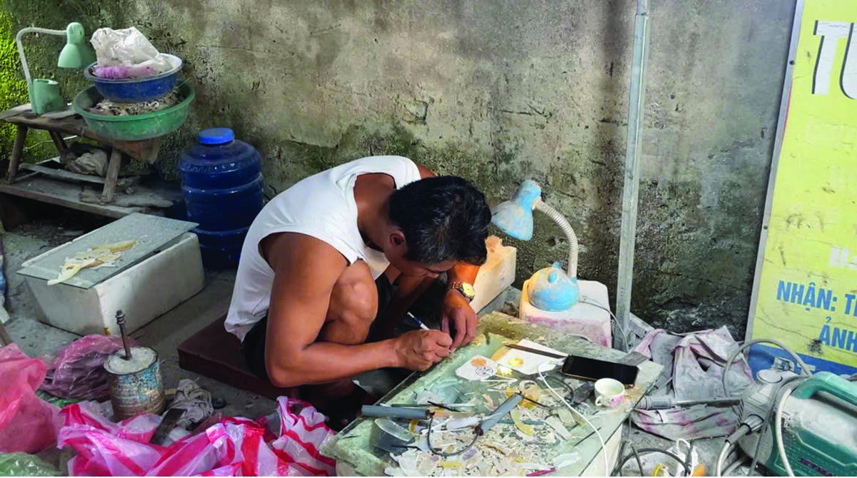 Bàn tay người nghệ nhân Chuôn Ngọ biến vỏ trai, vỏ ốc thành tác phẩm mang đậm dấu ấn Việt. Ảnh: Hoàng Thùy