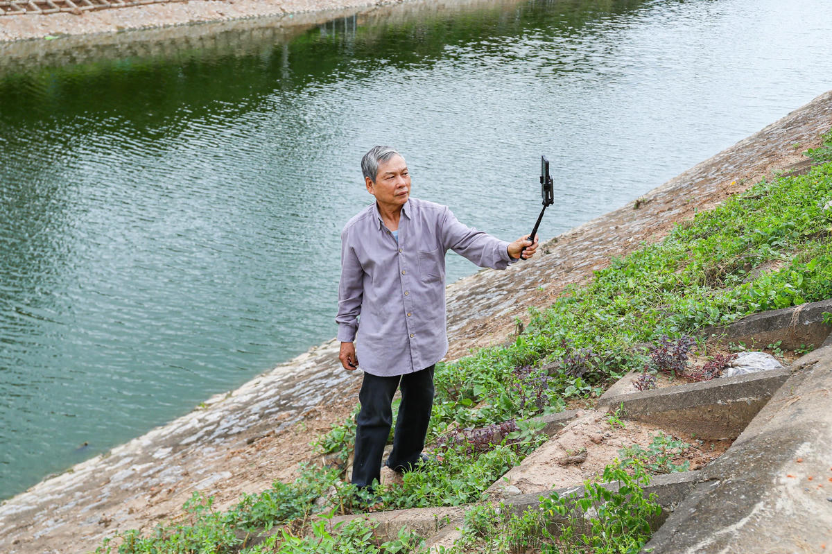 Thậm chí, người dân chụp ảnh cùng để lưu lại dòng nước trong xanh ở sông Tô Lịch.