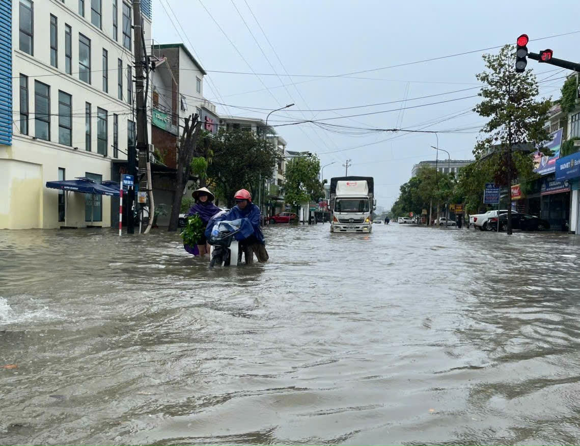 Sáng 27/9, nhiều tuyến phố ở Nghệ An ngập sâu, gây khó khăn cho phương tiện di chuyển qua đây. Ảnh: QT