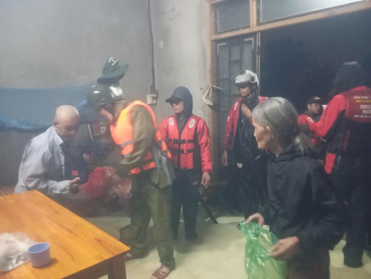 Công an phường An Cựu hỗ trợ người dân vùng ngập lụt đến nơi an toàn. Ảnh: CACC.