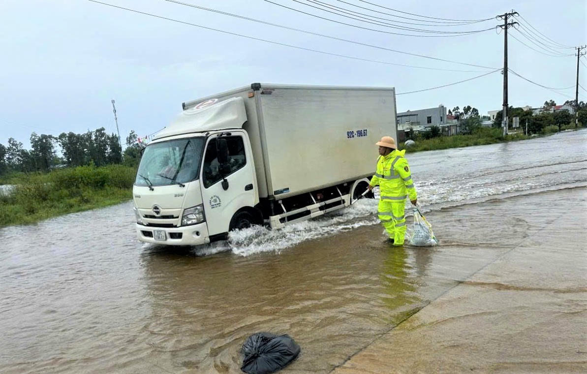Lực
lượng CSGT hướng dẫn xe lưu thông qua đoạn đường ngập nước. Ảnh: Công an cung cấp.