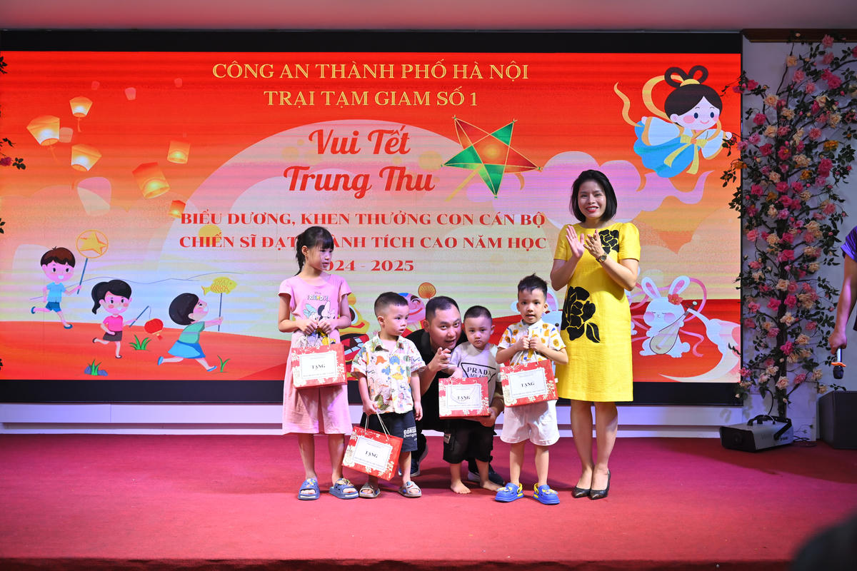 Đồng chí Trung tá Nguyễn Thị Vân Hạnh, Phó trưởng ban Phụ nữ Công an TP Hà Nội tặng quà cho các cháu có hoàn cảnh khó khăn. Ảnh: Quang Lộc.