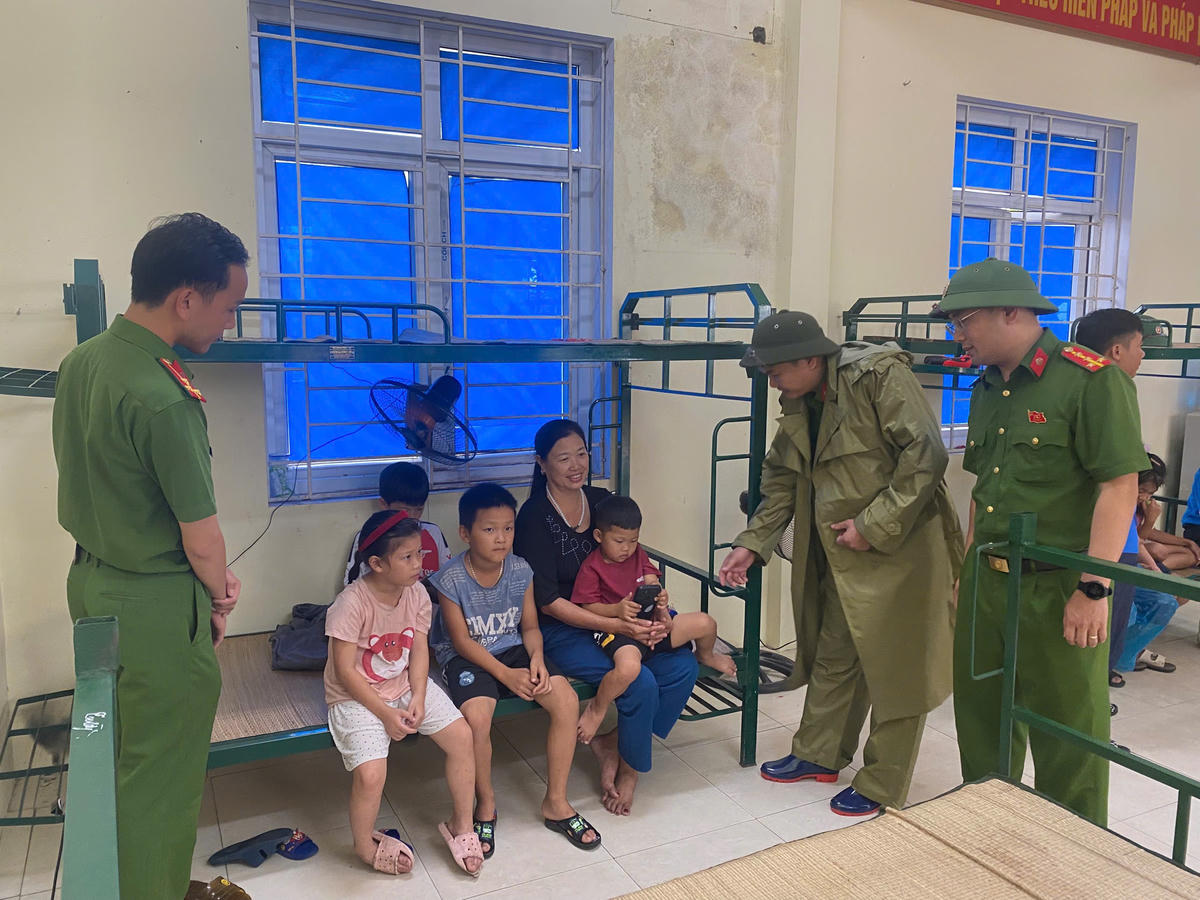 Lãnh đạo Công an phường Ngọc Sơn thăm hỏi, động viên người dân đi tránh trú bão ngày 28/9. Ảnh: CANS
